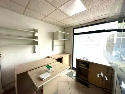 Surface de vente baignée de lumière par la vitrine, faux plafond et sol carrelé