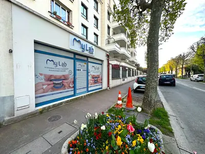 Le local dans son environnement : avenue arborée et stationnement en façade